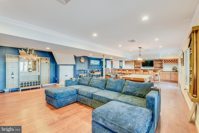 living room with bar, light wood-type flooring, ornamental molding, and billiards