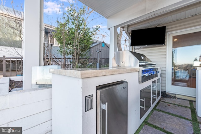 view of patio / terrace featuring exterior kitchen and a grill