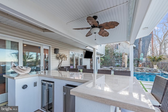 view of patio featuring ceiling fan, an outdoor bar, and wine cooler