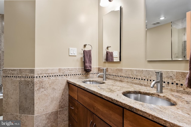 bathroom featuring vanity and tile walls