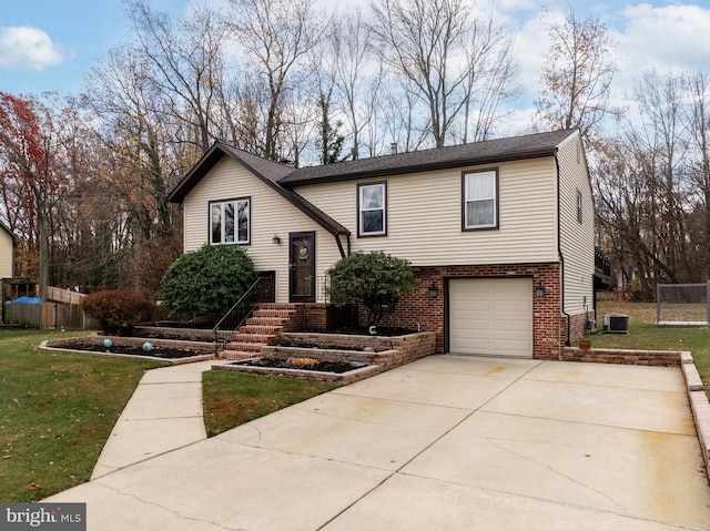 split foyer home featuring a garage and a front yard