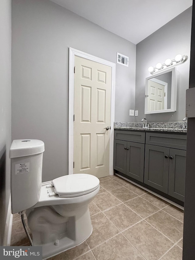 bathroom featuring toilet, vanity, and tile patterned floors