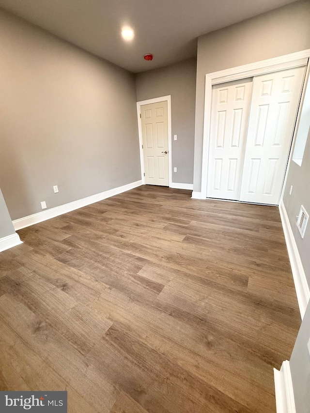 unfurnished bedroom featuring a closet and wood-type flooring