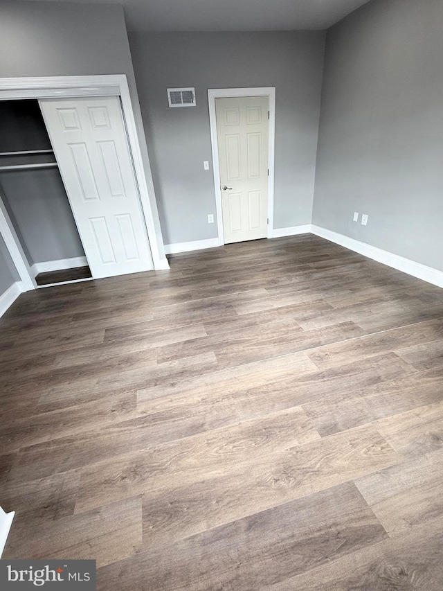 unfurnished bedroom featuring a closet and hardwood / wood-style flooring