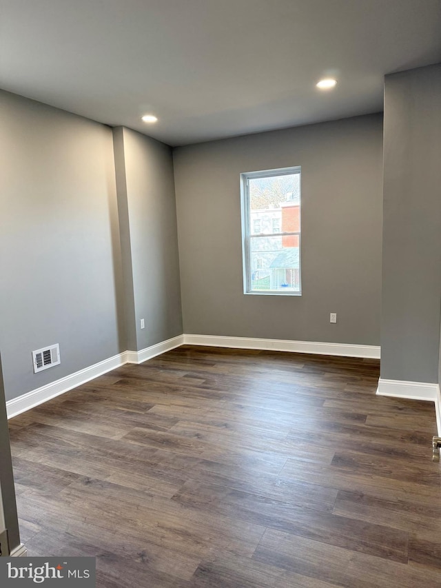 unfurnished room with dark hardwood / wood-style flooring