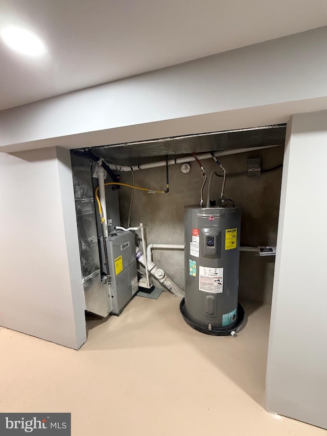 utility room featuring heating unit and electric water heater