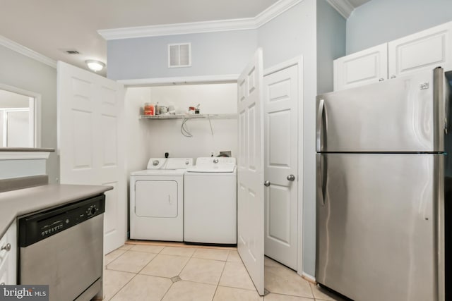 laundry area with light tile patterned floors, washing machine and dryer, and ornamental molding