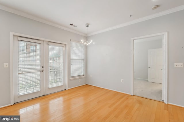 unfurnished dining area with hardwood / wood-style flooring, french doors, a notable chandelier, and ornamental molding