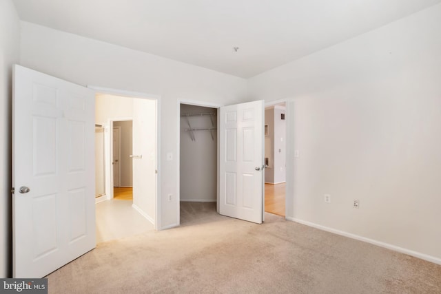 unfurnished bedroom featuring a closet and light colored carpet