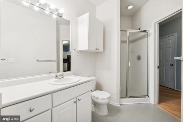 bathroom with tile patterned flooring, vanity, toilet, and a shower with shower door