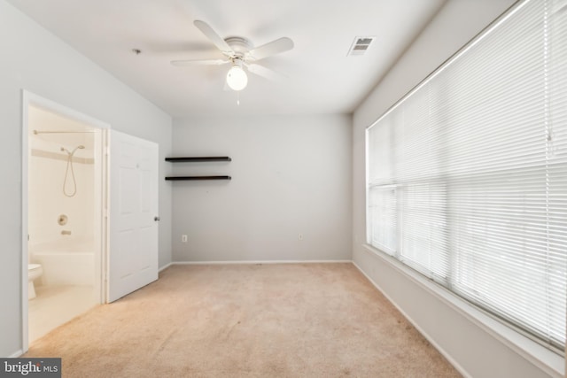 unfurnished bedroom with connected bathroom, ceiling fan, and light colored carpet