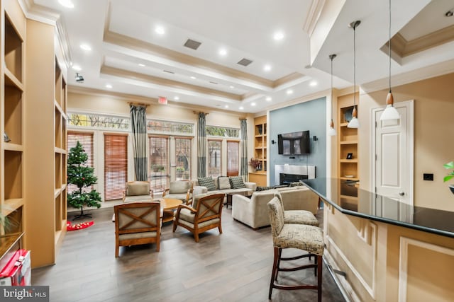 living room with dark hardwood / wood-style floors, a healthy amount of sunlight, and built in shelves