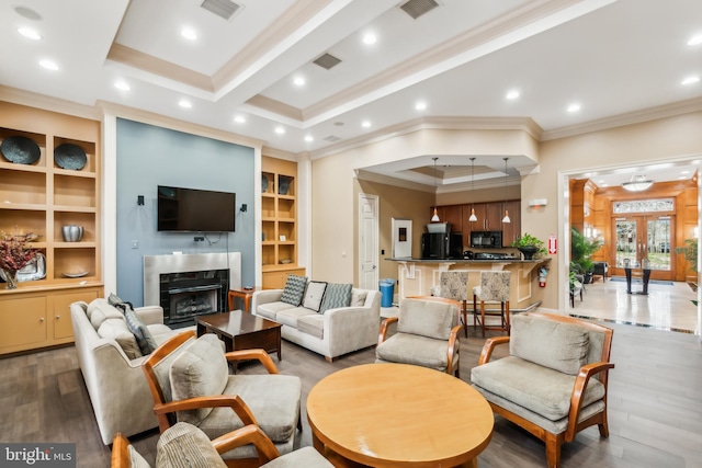 living room featuring crown molding, hardwood / wood-style floors, a high end fireplace, and beamed ceiling