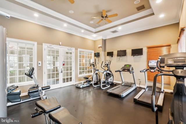 workout area featuring ceiling fan, crown molding, a tray ceiling, and french doors