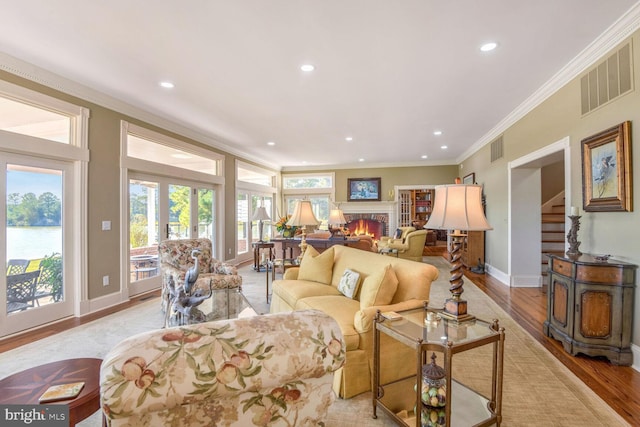 living room with crown molding and light wood-type flooring