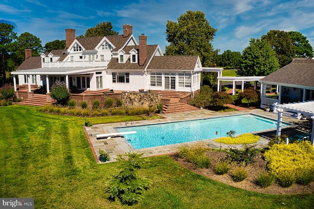 back of house featuring a lawn and a balcony