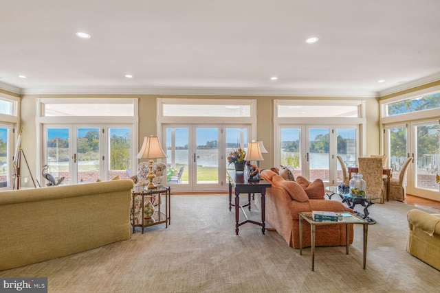 living room with a water view, light carpet, and french doors