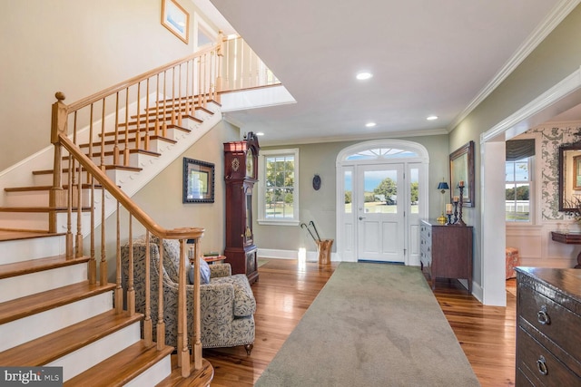 foyer with hardwood / wood-style flooring, plenty of natural light, and ornamental molding