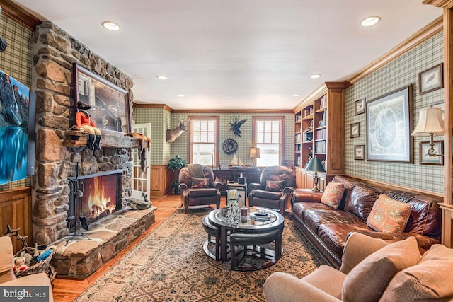 living room featuring light wood-type flooring, a fireplace, and ornamental molding