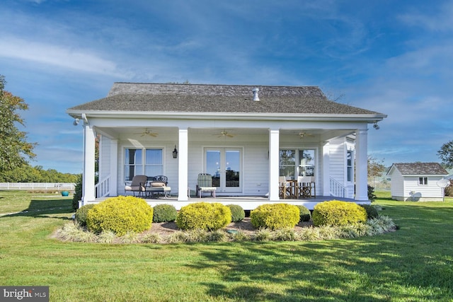 back of property with a porch, a yard, and ceiling fan