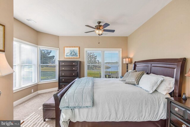 carpeted bedroom with multiple windows and ceiling fan