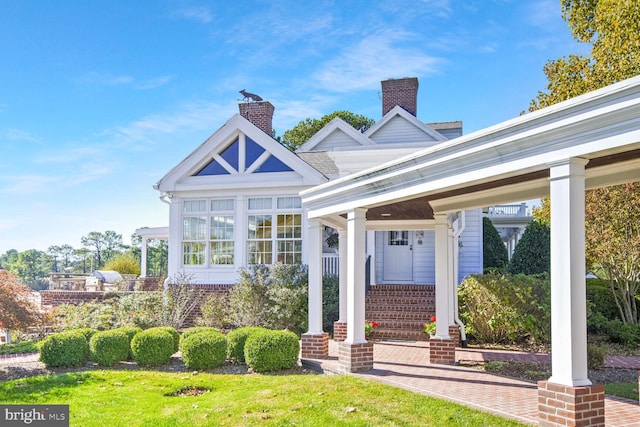 view of front of home featuring covered porch and a front lawn