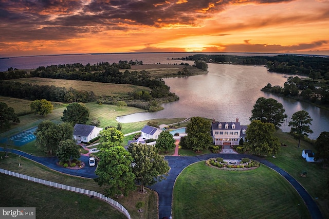 aerial view at dusk featuring a water view