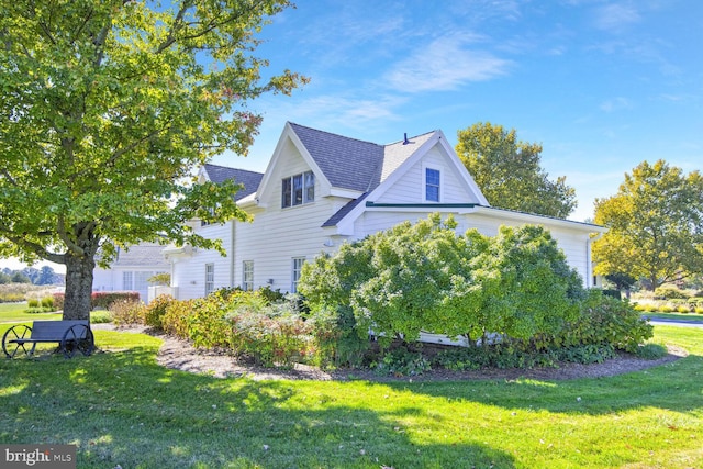 view of side of home with a yard