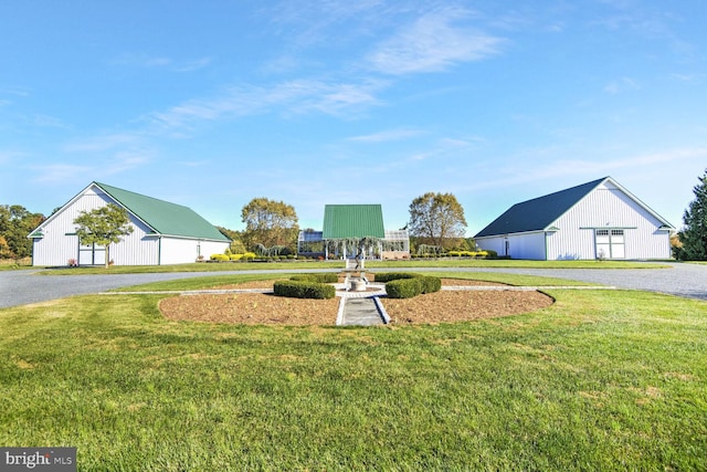 view of property's community with an outbuilding and a yard