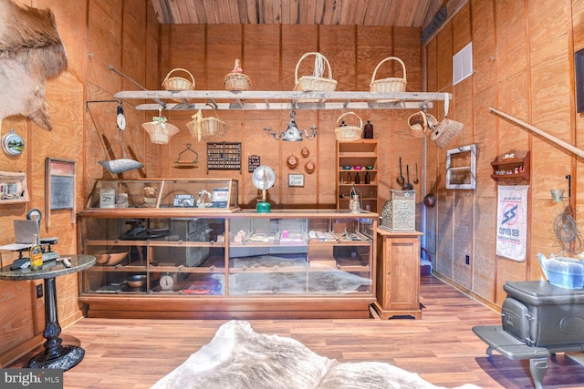 interior space featuring hardwood / wood-style flooring, a wood stove, and wooden walls