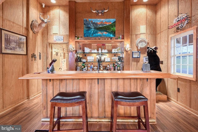 bar featuring wood walls and wood-type flooring