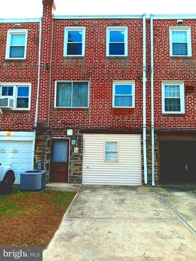 exterior space with central AC and a garage