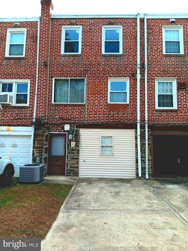 view of front facade with cooling unit and a garage