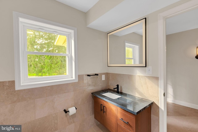 bathroom with vanity and tile walls