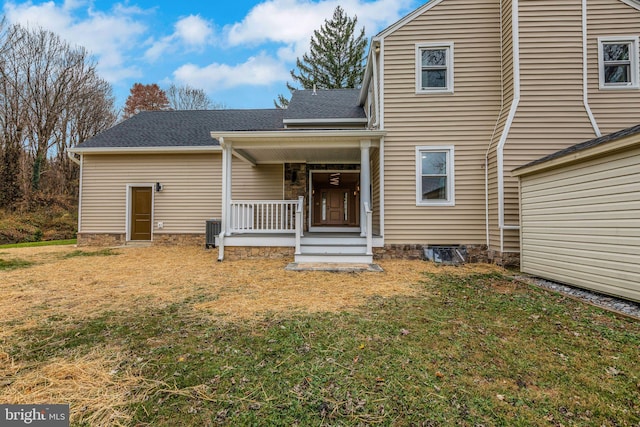 back of house featuring a lawn and covered porch