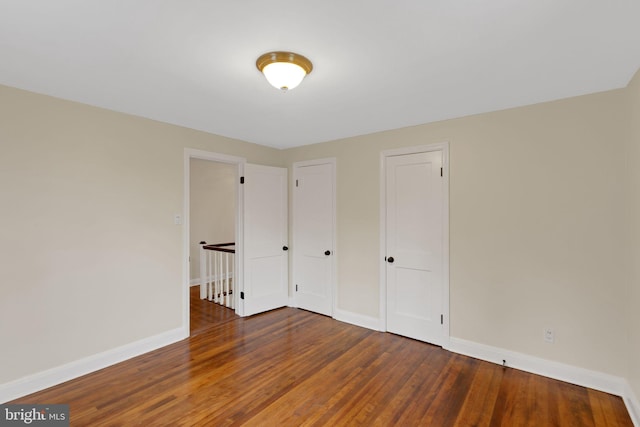 unfurnished bedroom with dark wood-type flooring