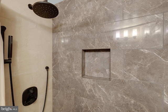 interior details featuring a tile shower