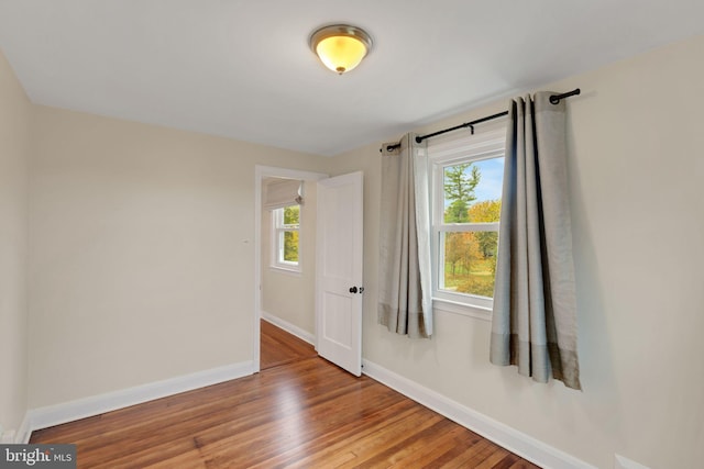 empty room featuring plenty of natural light and hardwood / wood-style floors