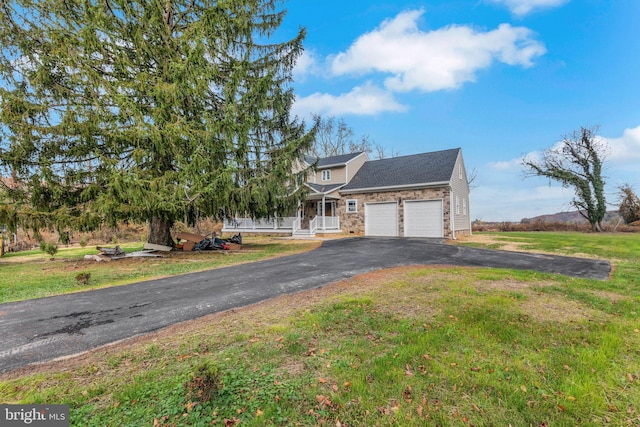 view of front of property featuring a porch, a front yard, and a garage