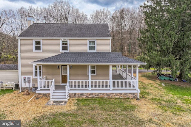 farmhouse inspired home with a front lawn and covered porch