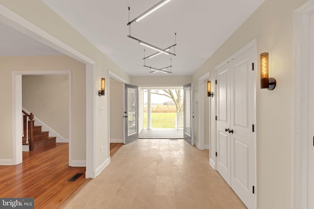 entryway with light wood-type flooring and a chandelier