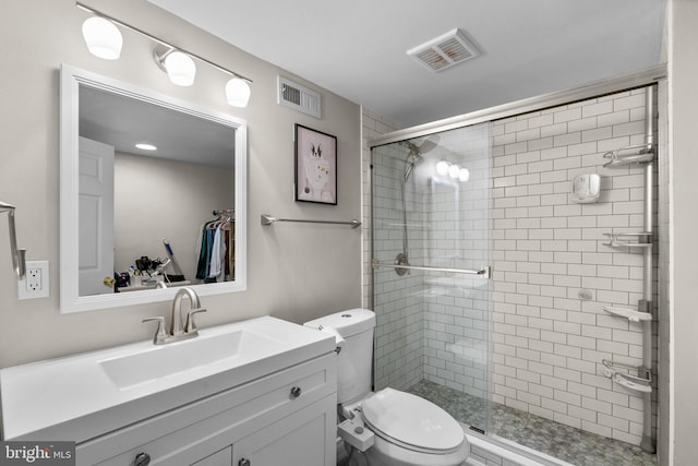 bathroom with vanity, a shower with shower door, and toilet