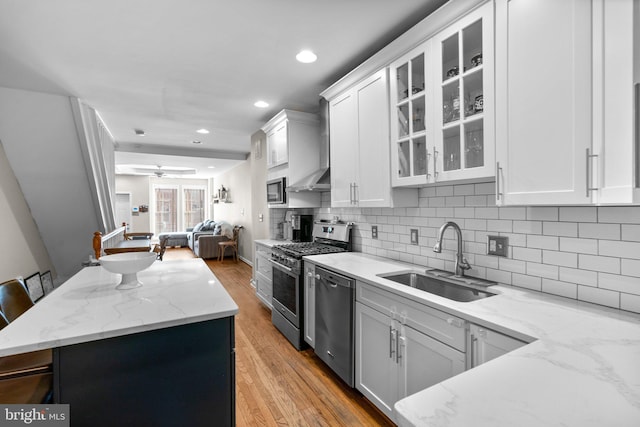 kitchen with white cabinetry, sink, a kitchen bar, and appliances with stainless steel finishes