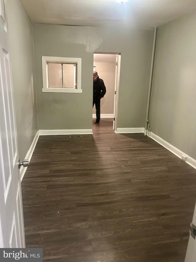 spare room with dark wood-type flooring