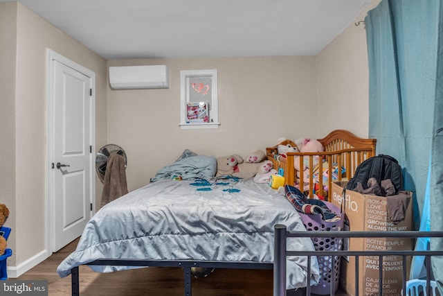 bedroom featuring hardwood / wood-style floors and a wall unit AC