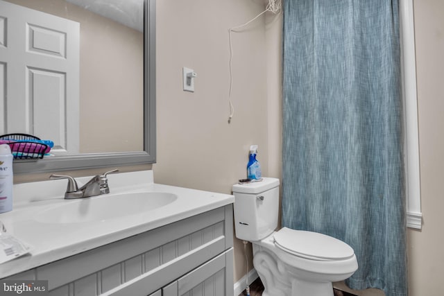 bathroom with curtained shower, vanity, and toilet