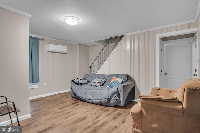 living area featuring light hardwood / wood-style floors, a wall mounted AC, and crown molding