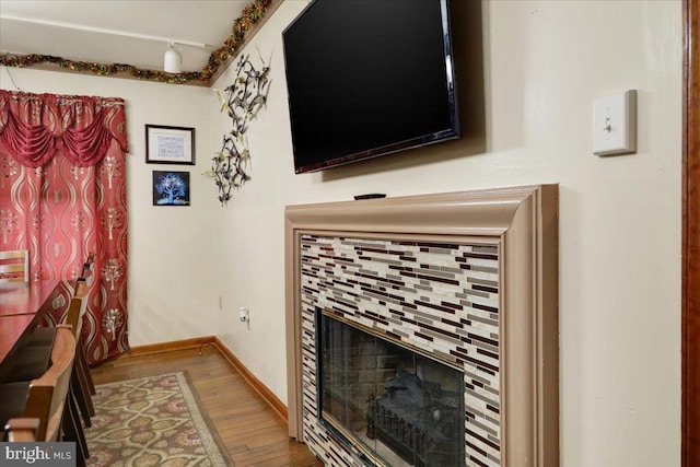 interior details featuring hardwood / wood-style flooring and a tiled fireplace