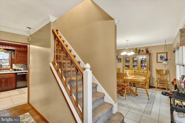 staircase with hardwood / wood-style floors, an inviting chandelier, and ornamental molding