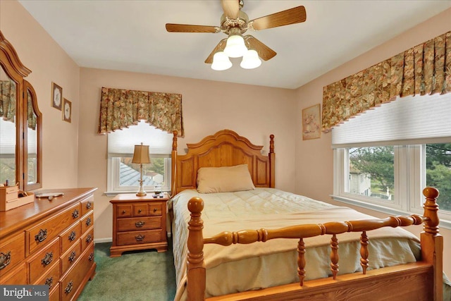 carpeted bedroom with multiple windows and ceiling fan